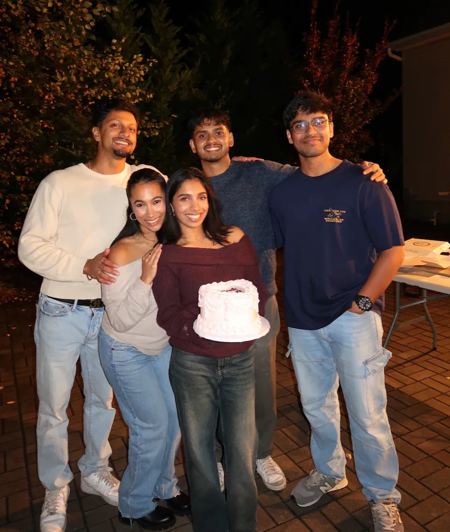 Surrounded by favorite people and a sweet pink cake on a cool evening outside.