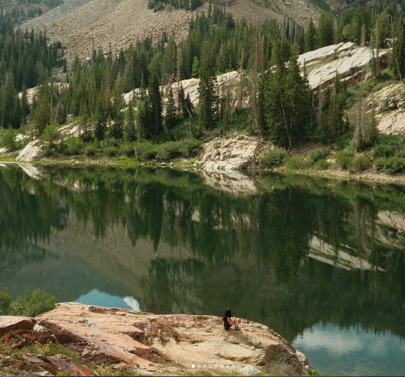Taking a quiet rest on the rocks by the calmest alpine water.